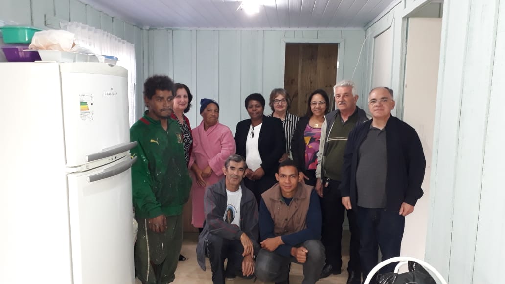 Dona Iraci com familiares, recebendo a casa reformada coma presença do Frei Gilson e de representantes das Pastorais da Ação Social e do Dízimo